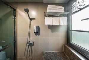 a bathroom with a shower and towels on a wall at WESU Weisu Service Apartment - Shenzhen University Nanshan Science and Technolog Park in Shenzhen