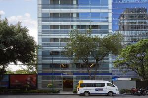 a white van parked in front of a tall building at City Express by Marriott EBC Reforma in Mexico City