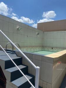 a swimming pool with stairs leading to a building at Casa de Temporada Ferreira in Olímpia