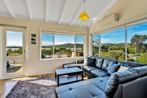 a living room with a couch and a large window at The Blue House in Coles Bay