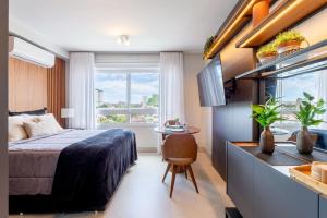 a bedroom with a bed and a table and a window at Likehome Connect in Porto Alegre