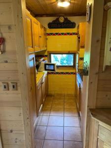 a small kitchen with a yellow tiled floor at Apartment with balcony and panoramic view between sky and mountains in Megève
