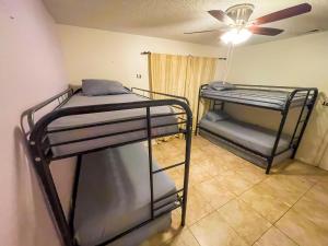 two bunk beds in a room with a ceiling fan at Beds & Sheets DOWNTOWN in Miami