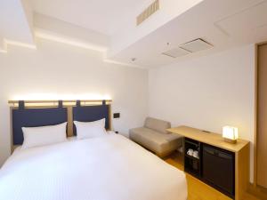 1 dormitorio con cama, escritorio y silla en hotel androoms Kyoto Shichijo, en Kioto