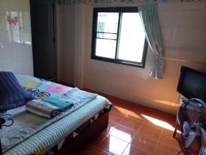 a small room with a bed and a window at NP guesthouse in Trat