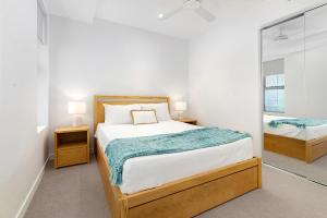 um quarto com uma cama grande e um espelho em Oceanus Bokarina Beach em Kawana Waters