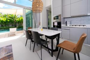 a kitchen and dining room with a table and chairs at Peykaa Estate Pool Villa by HCR in Phuket Town