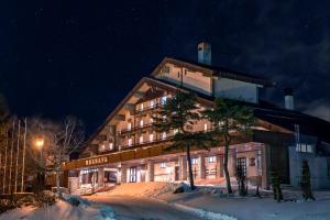 un edificio de hotel en la nieve por la noche en Madarao Kogen Hotel, en Iiyama