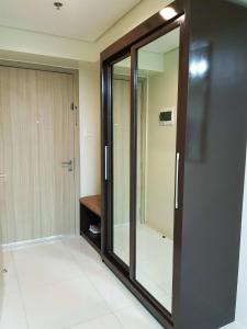 Puerta de cristal en una habitación con espejo en Studio unit at The Breeze Residence en Manila