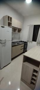 a kitchen with a white refrigerator and a counter at Morada do bosque in Capão da Canoa