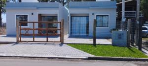 a gate in front of a blue and white house at Morada do bosque in Capão da Canoa