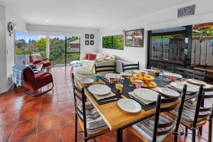 comedor y sala de estar con mesa y sillas en Bellevue Paradise - Tauranga Holiday Home, en Tauranga