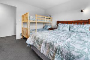 1 dormitorio con cama y estante para libros en Bellevue Paradise - Tauranga Holiday Home, en Tauranga