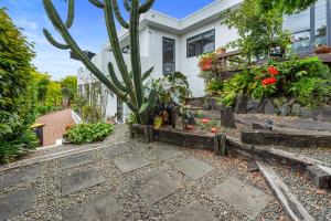 un jardín frente a una casa con un cactus en Bellevue Paradise - Tauranga Holiday Home, en Tauranga