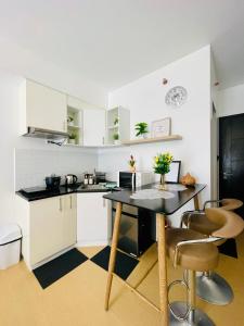 une cuisine avec des armoires blanches et une table et des chaises dans l'établissement Studio Unit with Balcony at Centrio Towers beside Ayala Mall Downtown CDO, à Cagayán de Oro