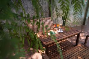 a wooden bench with a cup of coffee and a plant at Lanta Thip House by Swiss-Belhotel - SHA Plus in Ko Lanta