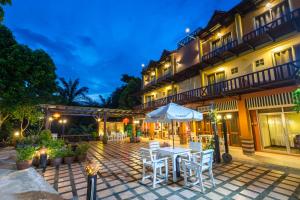 a patio with a table and chairs in front of a building at Lanta Thip House by Swiss-Belhotel - SHA Plus in Ko Lanta