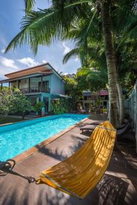 a hammock in front of a house and a swimming pool at Lanta Thip House by Swiss-Belhotel - SHA Plus in Ko Lanta
