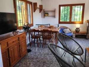 a living room with a dining room table and chairs at VILLAS COSETTE / ¡Descubre Villa Martina, tu oasis perfecto en la Costa Brava! Fabulosa piscina y zona de Barbacoa! - ES-209-4 in Caldes de Malavella
