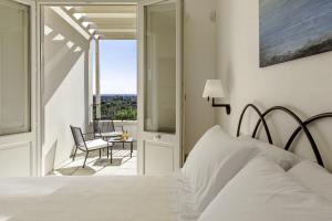 a bedroom with a bed and a balcony with a table at Tenuta Monticelli in Alezio