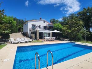 uma villa com piscina em frente a uma casa em Casa Caldes de Malavella, 4 dormitorios, 8 personas - ES-209-4 em Caldes de Malavella