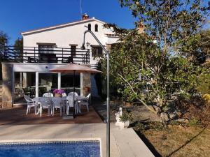 een patio met een tafel en stoelen en een parasol bij Casa Caldes de Malavella, 4 dormitorios, 8 personas - ES-209-4 in Caldes de Malavella