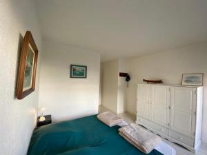1 dormitorio con 1 cama azul y armario blanco en Appartement Capbreton, 2 pièces, 4 personnes - FR-1-413-230, en Capbreton