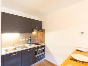a kitchen with brown cabinets and a sink at Appartement confortable 6 personnes à Peyragudes - FR-1-695-42 in Germ +8 photos