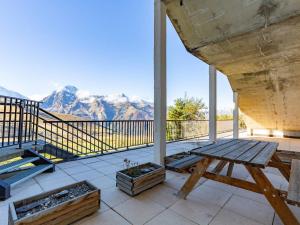 a porch with a bench and mountains in the background at Appartement confortable 6 personnes à Peyragudes - FR-1-695-42 in Germ