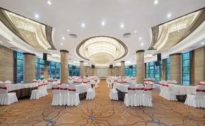 een feestzaal met witte tafels en stoelen bij Arthur International Hotel - Provincial Science and Technology Museum Xianghu Branch in Zhengzhou