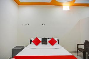um quarto com uma cama branca e almofadas vermelhas em OYO Flagship Hotel Midtown 2 em Noida