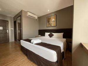 a bedroom with a large bed with white sheets at Cebu Capitol Central Hotel & Suites powered by Cocotel in Cebu City