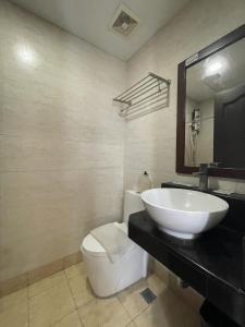 a bathroom with a white sink and a toilet at Cebu Capitol Central Hotel & Suites powered by Cocotel in Cebu City