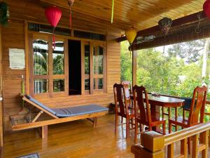 un porche de una casa con mesa y sillas en Nana Home, Entire Amazing Wooden Chalet en Phu Quoc