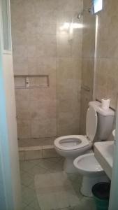 y baño con aseo y ducha. en Aparthotel Continental en San Miguel de Tucumán