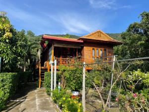 a wooden house with a garden in front of it at Nana Home, Entire Amazing Wooden Chalet in Phu Quoc