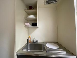 Il comprend une petite cuisine avec un lavabo et des toilettes. dans l'établissement A&C STAY Shin-Osaka 41, à Osaka
