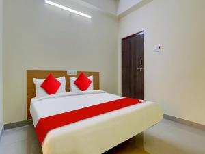 1 dormitorio con 1 cama grande con almohadas rojas en Hotel RBS NFC Road, en Maula Ali