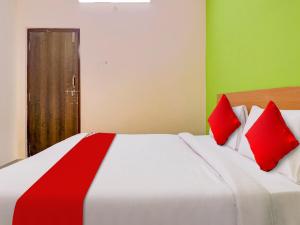 1 dormitorio con 1 cama blanca grande con almohadas rojas en Hotel RBS NFC Road, en Maula Ali