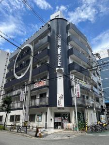 un bâtiment avec un panneau sur son côté dans l'établissement A&C STAY Shin-Osaka 41, à Osaka