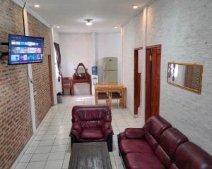 sala de estar con sofá y TV en Lucia Cottages en Sukarame