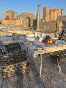 una mesa y sillas con fruta en el patio en Hotel Minor, en Samarkand