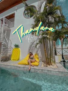 班克蘭的住宿－Thandara kohlarn，坐在游泳池黄色枕头上的女人