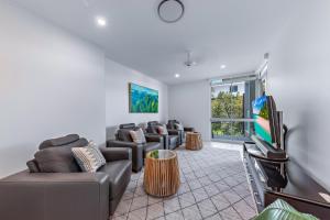 uma sala de estar com sofás e uma televisão de ecrã plano em Pavilions 9 & Buggy - Hamilton Island em Hamilton Island