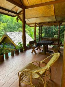 een patio met een tafel en stoelen op een veranda bij Shaya’s Green Hideaway 