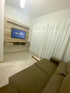 ein Wohnzimmer mit Couch und Flachbildfernseher in der Unterkunft Casa em Balneário Camboriú in Balneário Camboriú