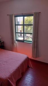 a bedroom with a bed and a window at Castillo Del Lago - Carlos Paz - D26 in Villa Carlos Paz