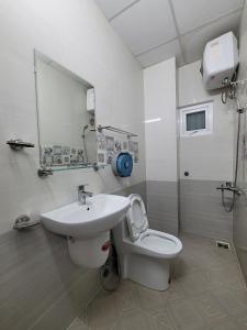 La salle de bains est pourvue d'un lavabo, de toilettes et d'un miroir. dans l'établissement Tiny Tigers Hostel, à Đà Lạt