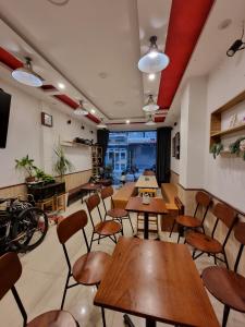 un restaurante con mesas y sillas en una habitación en Tiny Tigers Hostel, en Da Lat
