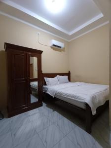 um quarto com uma cama e uma televisão no tecto em OYO 93340 Angsana Aglow Homestay em Duri